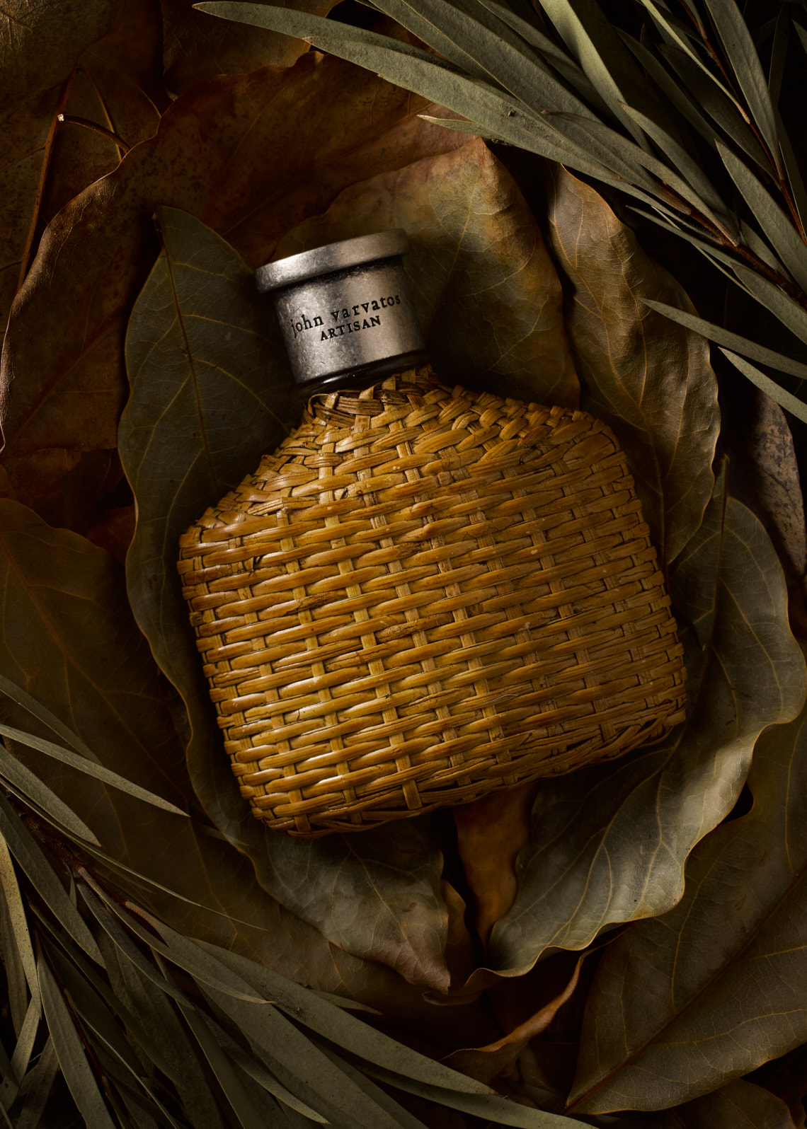 John Varvatos  Cologne surrounded by brown dried leaves