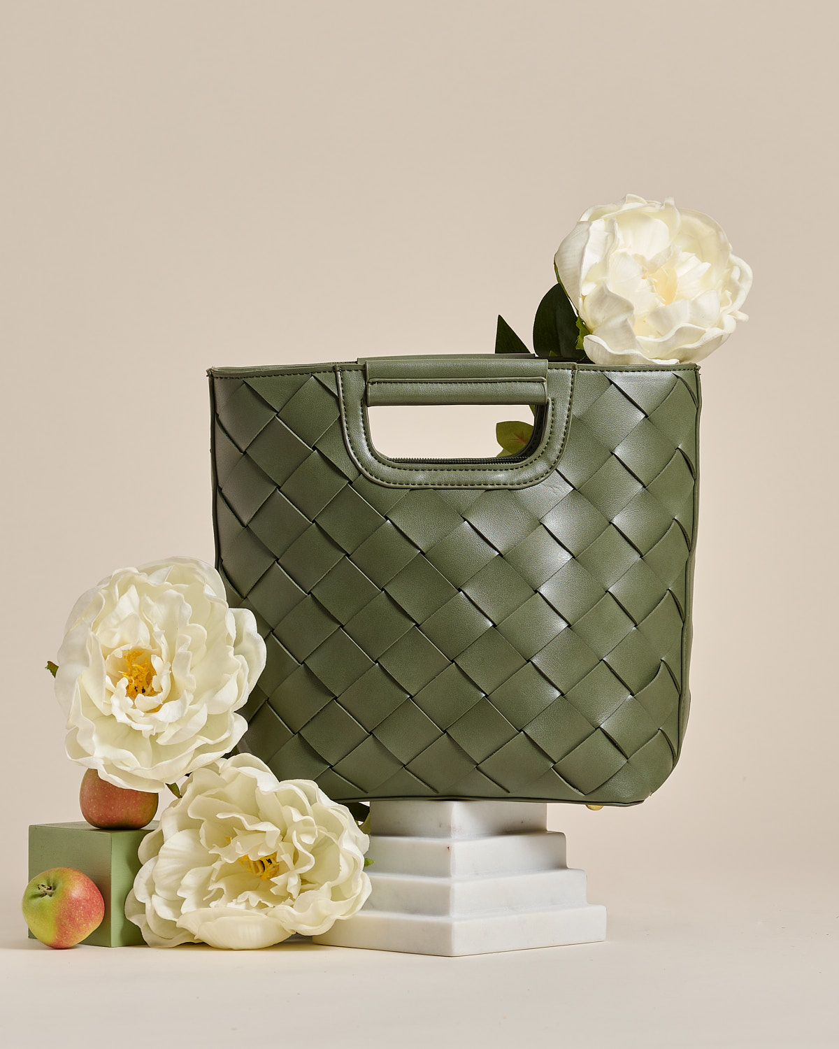 Melie Bianco with floral on a white step podium 
