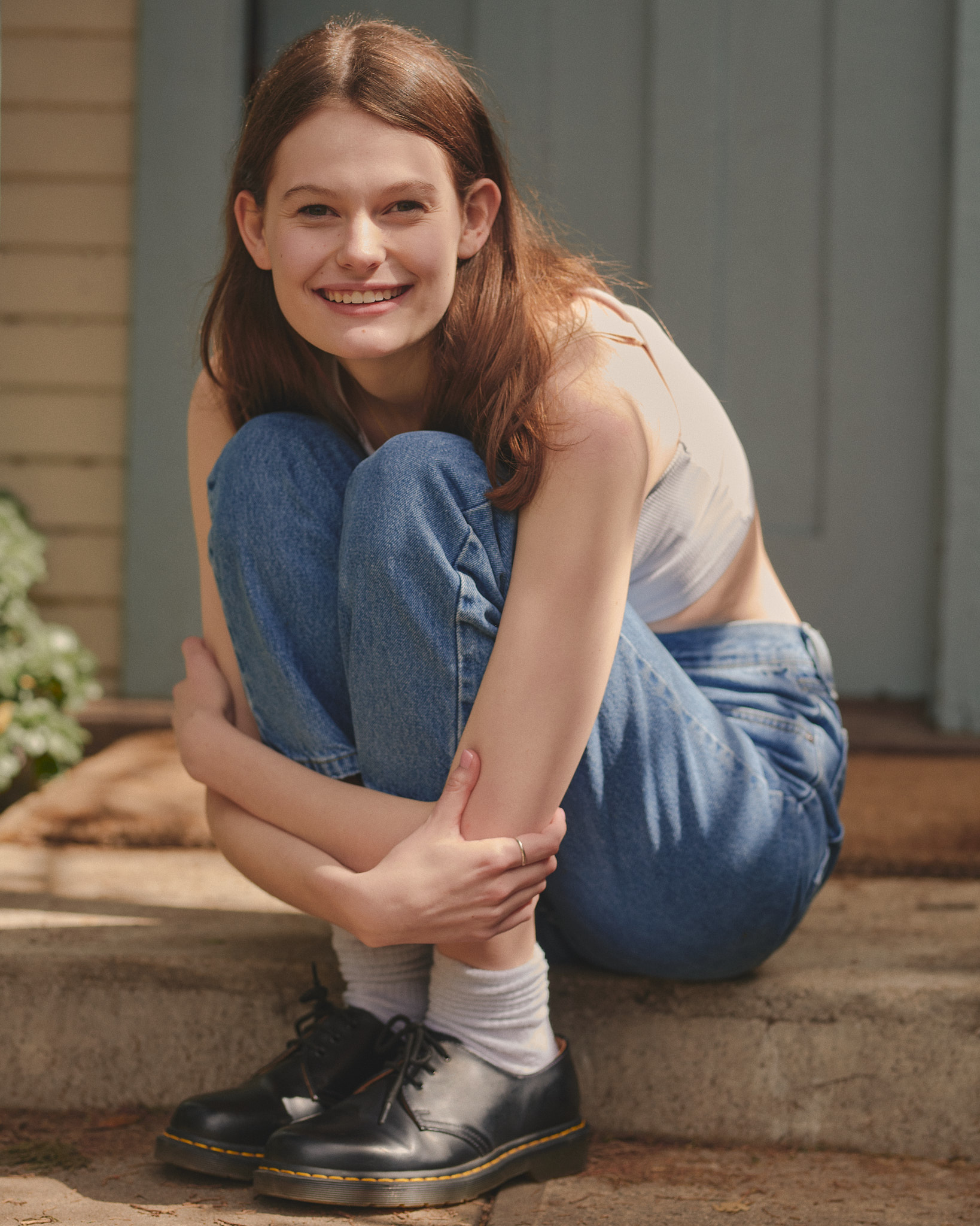 Wilhelmina Model Grace Bayer smiling while crouching in front of the door step