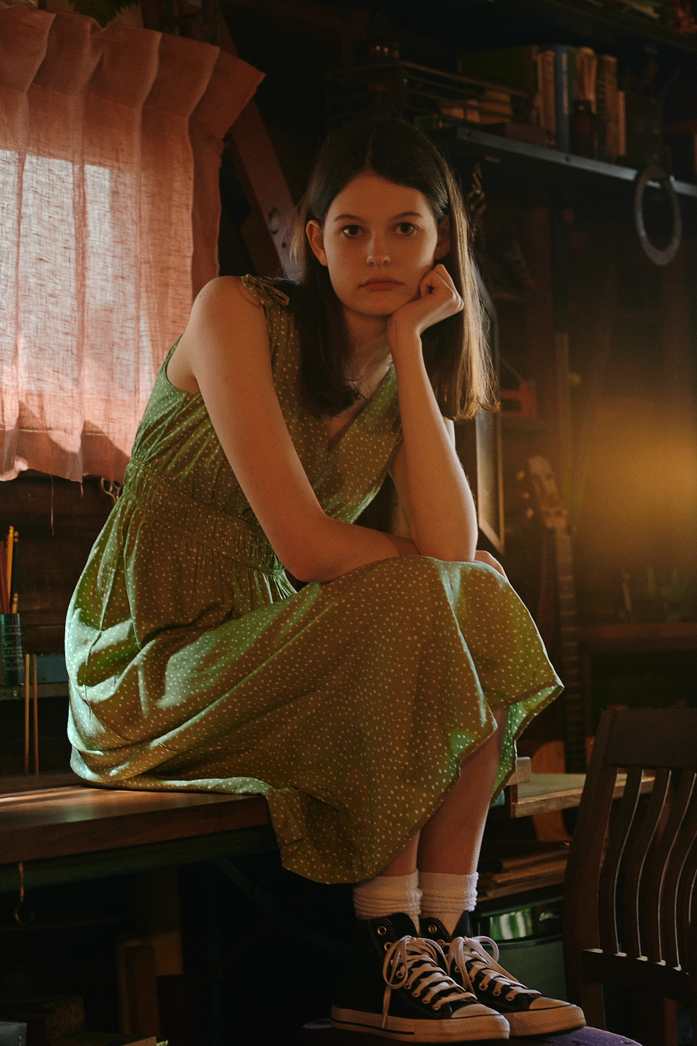 Wilhelmina Model Grace Bayer sitting on a wooden table wearing green dress